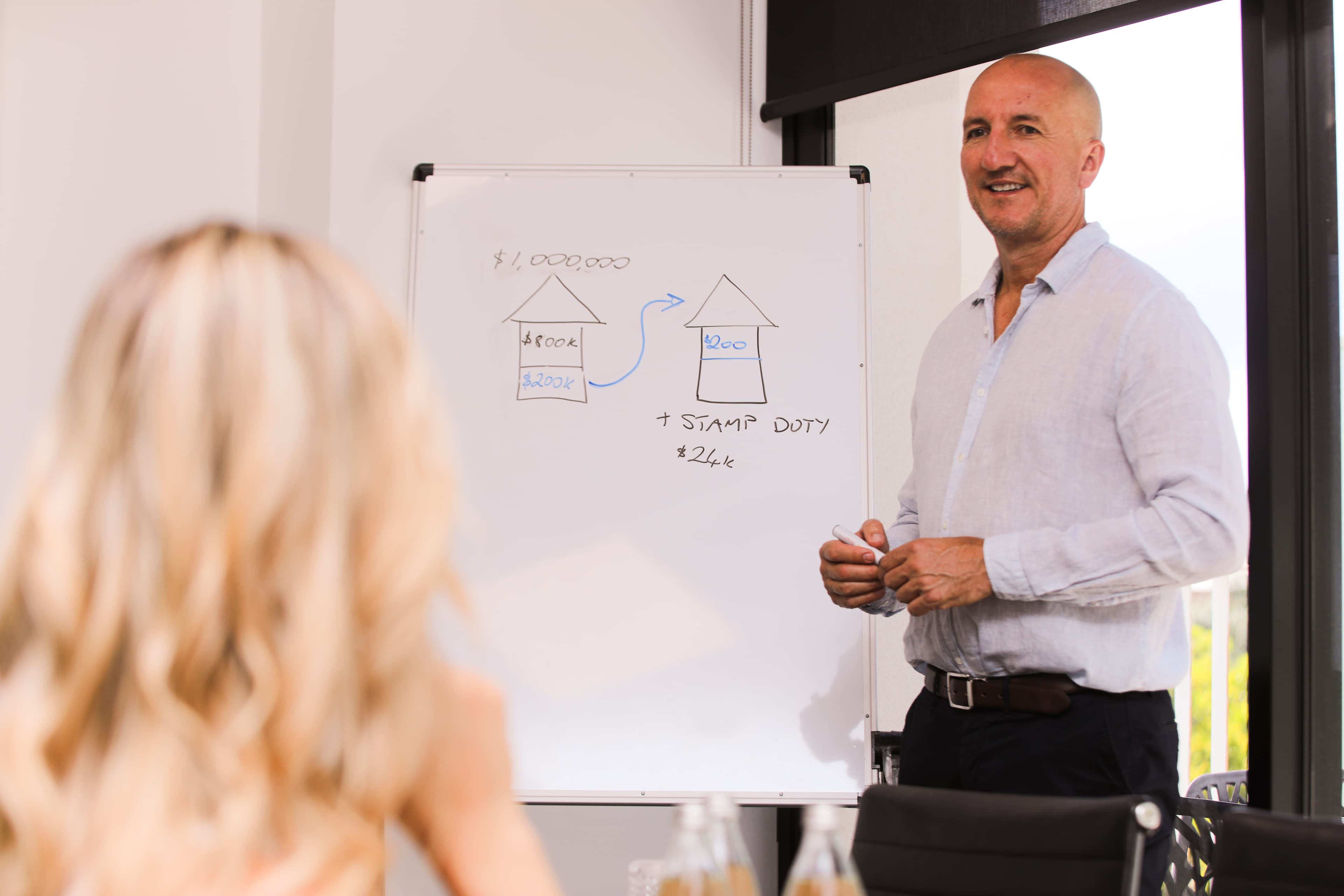 Russell Hall explaining deposit and stamp duty on a whiteboard